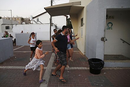 Israelis in Ashkelon run for shelter following a missile alert during Operation Protective Edge