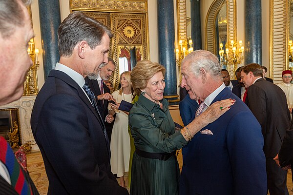 Pavlos (left) and his mother, Anne-Marie (middle), at the coronation reception of Charles III (right).