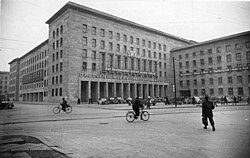 The former Air Ministry building in Berlin, then named 'House of the DWK', was the seat of the German Economic Commission (DWK). The title above the pillars is Deutsche Wirtschaftskommission. Above this the DWK logo and a banner with the title 'The Two-Year Plan secures our future' can be seen. The banner on the right reads "Two-Year Plan = Work and Bread * Marshall Plan = Ruin and Despair". Date of photo: 8 January 1949. Bundesarchiv Bild 183-19000-4055, Berlin, Leipziger Strasse, Deutsche Wirtschaftskommission.jpg