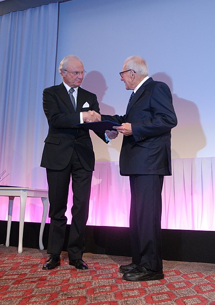 Carl XVI Gustaf of Sweden presents the Crafoord Prize to Munk.