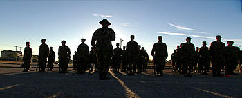 English: A drill sergeant with rows of recruit...