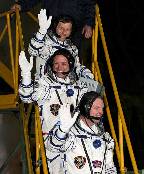 Borisenko, Garan, and Samokutyaev wave farewell from the bottom of the Soyuz rocket prior to their launch.