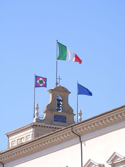 The Italian flag flying on the top of the Quirinal Palace. From left to right, the Presidential Standard of Italy, the tricolour and the flag of the European Union.