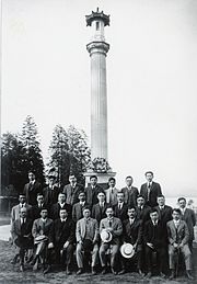 Formal picture of 24 Japanese-Canadian men in suits, seated and standing before the Japanese Canadian War Memorial, c. 1920