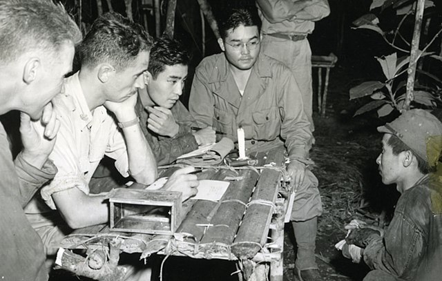 MIS interrogators Phil Ishio and Arthur Ushiro question a prisoner taken in the Buna campaign