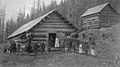 Men and a woman posed outside a log cabin, unidentified location, Washington, ca 1880s (WASTATE 2430).jpeg