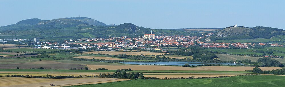 Panoramatický pohled od jihu z vrchu Kreuzberg u vsi Kleinschweinbarth. Vlevo Pavlovské vrchy, uprostřed Mikulov, vpravo Svatý kopeček s kaplí sv. Šebestiána a zvonicí.