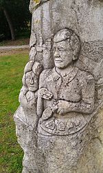 Stone relief depiction of Stanley West holding an archaeological trowel at West Stow. Stanley West.jpg