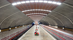 Platforma cu platforma centrală și cele două șine, în centrul băncilor roșii.