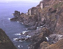 Two buildings set part of the way up a steep cliff