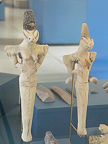 Photograph of two ceramic figurines with breasts arms and incised eyes