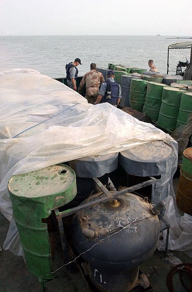 File:US Navy 030321-N-4655M-029 Coalition Navy Explosive Ordnance Disposal (EOD) team members inspect camouflaged mines hidden inside oil barrels on the deck of an Iraqi shipping barge.jpg