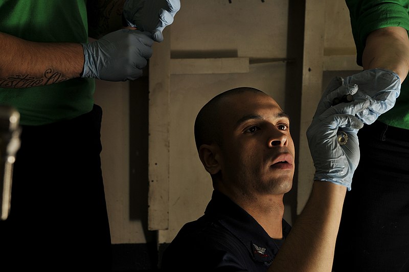 File:US Navy 120112-N-ZI635-100 A shipmate hands bolts to Aviation Structural Mechanic 2nd Class Christian Samaras as he performs maintenance on the ti.jpg