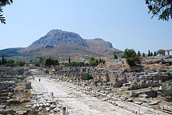 Antiikin Korintin arkeologista aluetta: Lekhaionin tie, taustalla Akrokorintti.