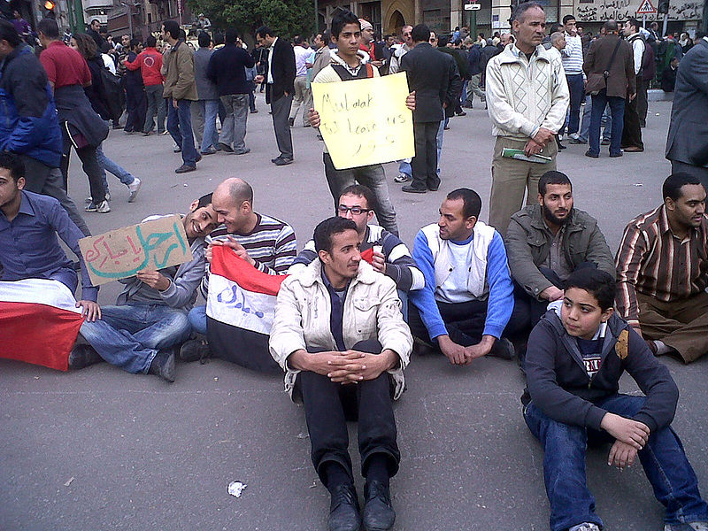 File:2011 Egypt protests - sitting line of men.jpg