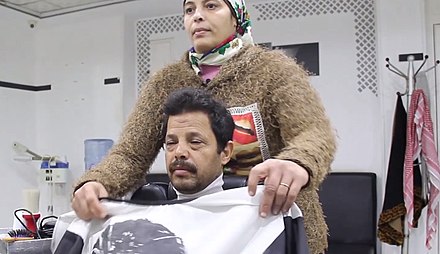 An Egyptian Muslim woman who works in a men's hairdresser. She described to be "confront the customs and traditions of her society and conquer their criticism."