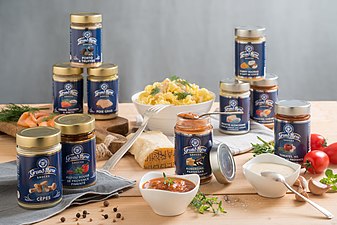 Fotografia che mostra scatole di salsa con la scritta "Grand'Mère" tra altri prodotti alimentari.