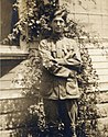 A young man in vintage Boy Scout uniform, arms folded