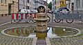 Der Brunnen vor dem Landratsamt Das Thema des Brunnens von Helmut Lutz einem Breisacher Bildhauer ist Aus drei Quellen schöpfen diese schützen und sich daraus entfalten Diese 3 Quellen sind *Natur *Geschichte *Lebensqualität Aus diesem Grund sind sie von geöffneten Eisenkugeln umheben und geschützt. Das Wasser wird in Schöpfgefäßen aufgefangen und weitergegeben. Die Schmetterlingsflügel aus Eisen sind beweglich und stehen für Entfaltung Der den Brunnen umgebende Graben führt als Bächlelauf an seinem Ende zu einem Poller