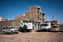 Die CADUS-Einsatzfahrzeuge und ein Anhänger des Mobile Hospitals vor einem mehrstöckigen Gebäude