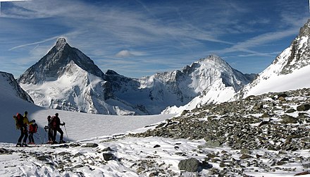 Ski mountaineers resting in front of the Matterhorn and Dent d'Hérens