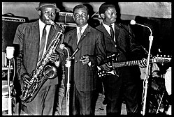 Franco Luambo (right), Isaac Musekiwa (left), and Joseph "Mujos" Mulama (center) in Leopoldville, ca. 1963 Isaac Musekiwa, Joseph "Mujos" Mulama et Francois "Franco" Luambo Makiadi.jpg