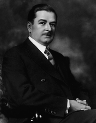 Fotografia em preto e branco de um homem sentado.