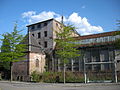 La porcherie en 2006 (à gauche) ; l'usine en arrière plan (détruite en 2009)