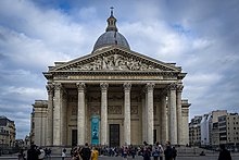 The facade of the Pantheon in Paris features a triangular pediment, featuring two symmetrical straight lines sloping to the ends of a horizontal cornice. Pantheon - Paris.jpg