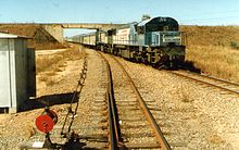 1556 and a 1720 class haul the northbound Sunlander through Yabulu in 1991 QR loco 1556 and a 1720 class haul the Sunlander northbound through Yabulu, ~1991.jpg