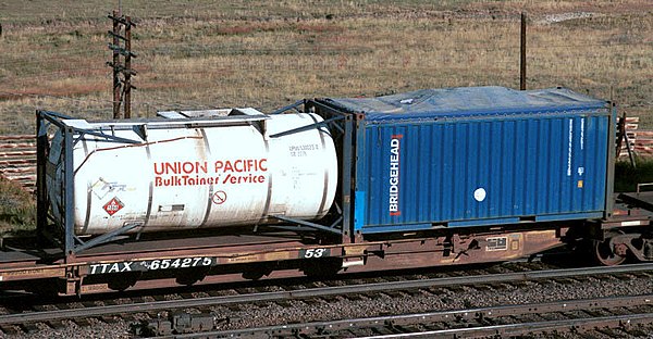 A flatcar with a 20 ft tanktainer and an open-top 20 ft container with canvas cover