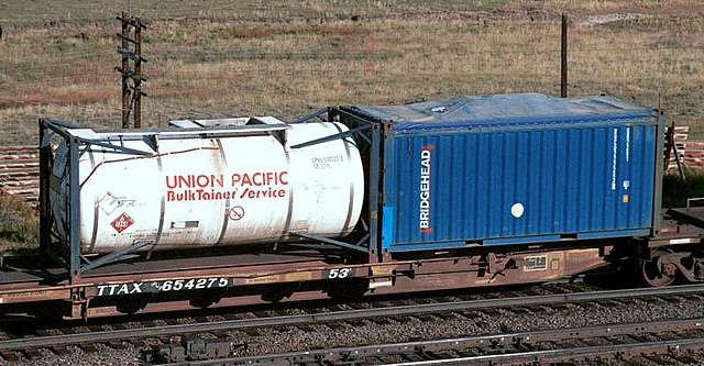 A spine car with a 6 metres (20 ft) tank container and an open-top intermodal shipping container with canvas cover.