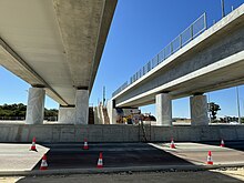 Two concrete bridges over a road viewed from underneath