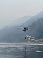 Vrtulník PZL W-3 Armády ČR po nabrání vody k hašení z Labe do bambi vaku.