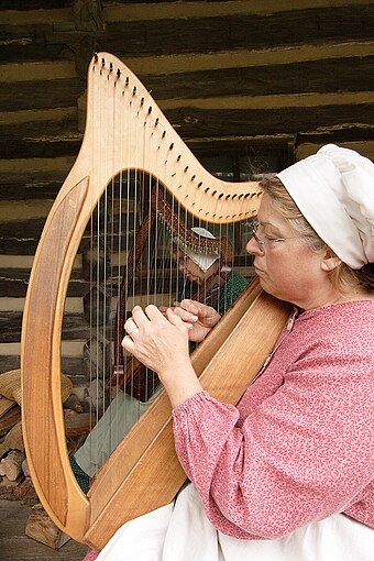 New Salem Village re-enactor playing a Celtic harp.