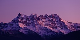 Montagne innevate davanti a un cielo viola.