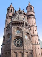 Wormser Dom: Westchor 1181, großes Fenster ohne Kapitell­chen; polygonale Chor­form, hier wegen gedrängter Rund­fenster, da­nach von der Gotik übernommen