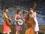 Mulheres tocando banjo, violão, baixo e violino