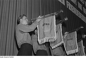 Aficionados con las banderas de la Unión de la Juventud Alemana Libre en fanfarria