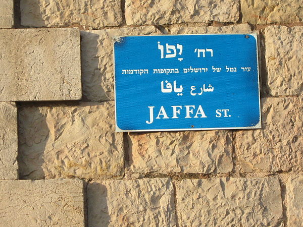 Reflective street sign commemorating Jaffa as the "port city of Jerusalem in ancient times"