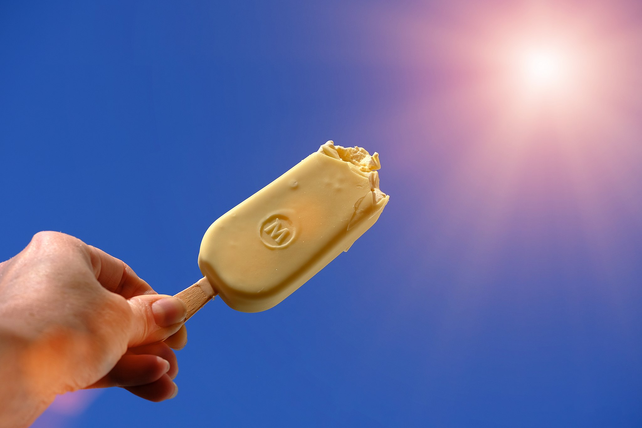 Magnum ice cream bar held up to sun