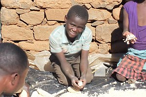 A young boy prepares Mielie pap, the staple food in Lesotho. Mielies.jpg