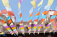Rows of brightly colored papel picado in intricate designs flutter in the breeze