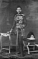 King Prajadhipok in the scarlet uniform, with the old style helmet to the right of the picture