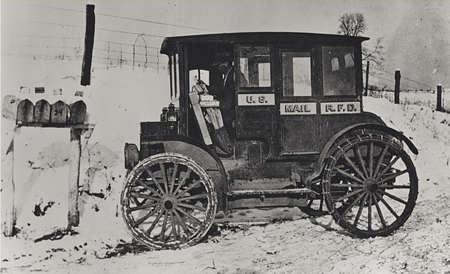 Rural carrier in an early electric vehicle, circa 1910