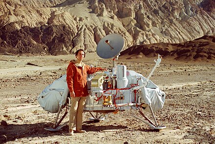 Astronomer Carl Sagan stands next to a model of a Viking lander to provide scale