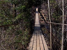 A swingbridge spans Cane Creek, near the nature center