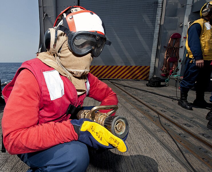 File:US Navy 110726-N-OV802-156 Ship's Serviceman Seaman Jarvis Jones serves as the nozzleman of a hose team while participating in a helicopter crash.jpg