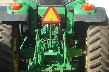 A PTO (in the box at the bottom) in between the three-point hitch of a tractor.