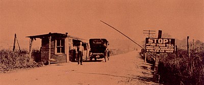 Tollgate in Ambrose County near Lynchburg, Va. The sign warns that there is a fine of $10. for exceeding the speed limit of 6 m.p.h.